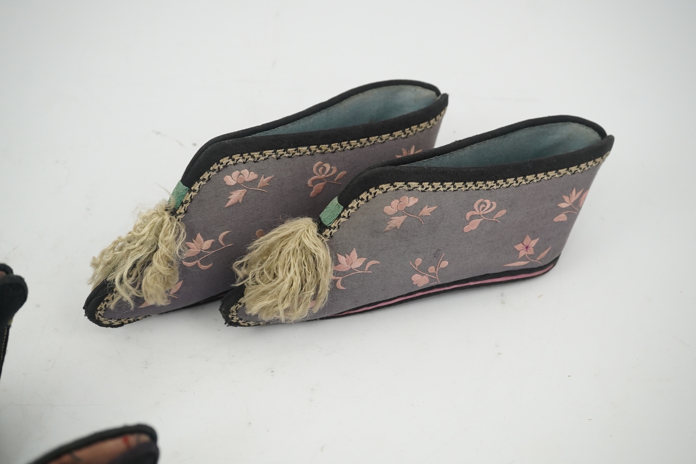 Three pairs of late 19th / early 20th century Chinese ladies embroidered silk shoes, for bound feet, one with sheep’s wool pom-poms, together with a similar a pair of silk embroidered ankle boots and pair of decorative r